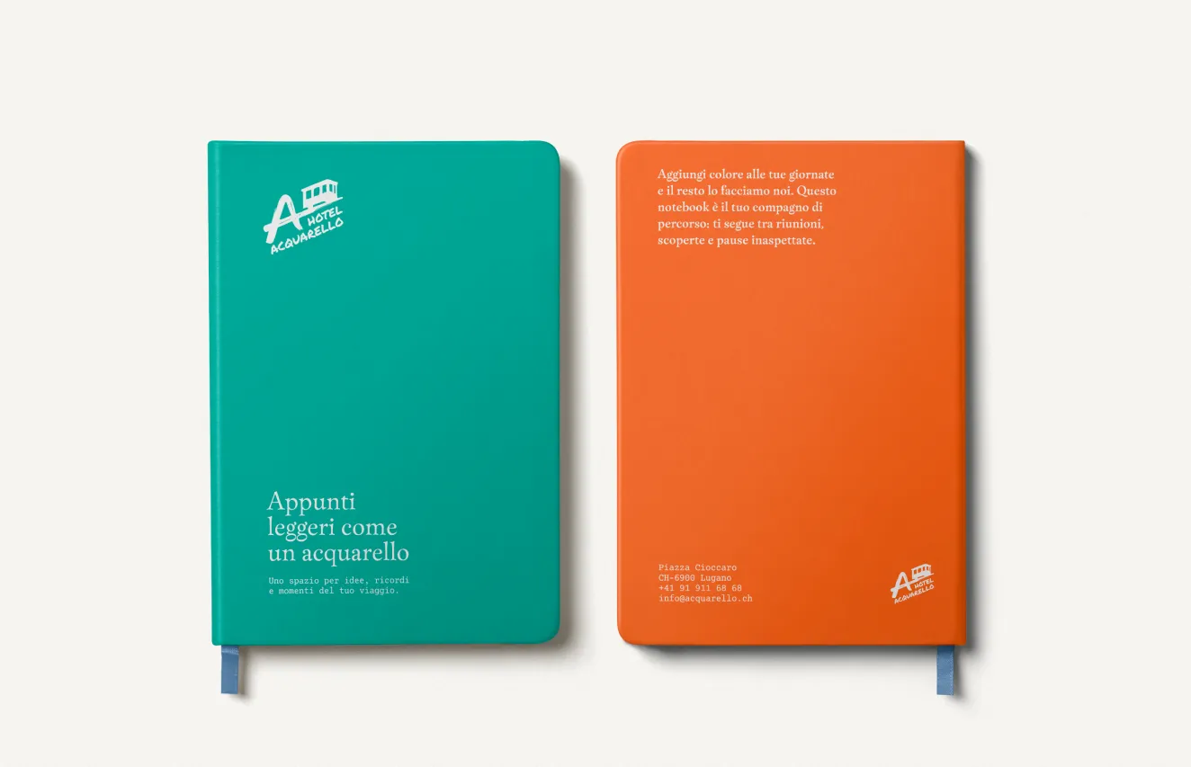 Hotel Acquarello, aqua green and orange notebook with logo and tagline "Notes as light as a watercolour"