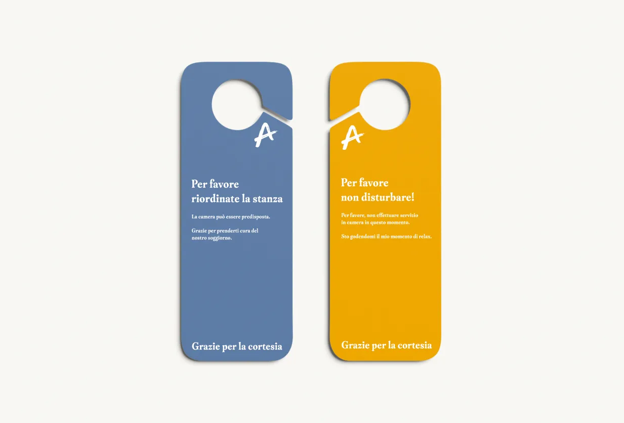 Hotel Acquarello, blue and yellow door hangers with "please clean the room" and "do not disturb" requests