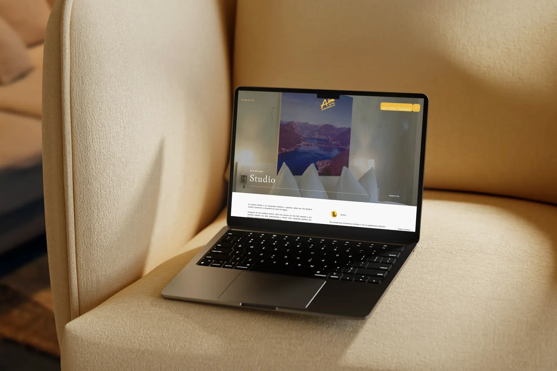 Hotel Acquarello, laptop mockup on beige armchair with Studio room page and panoramic photo